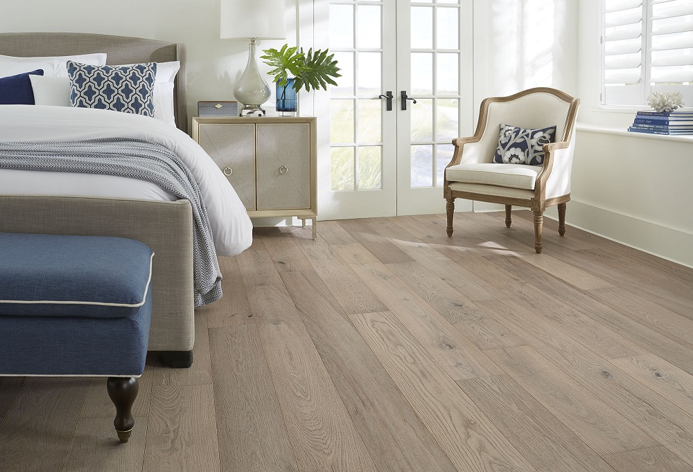 Light hardwood floors in coastal master bedroom