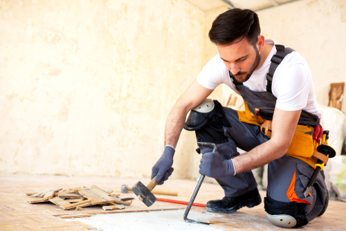 young worker removing old flooring